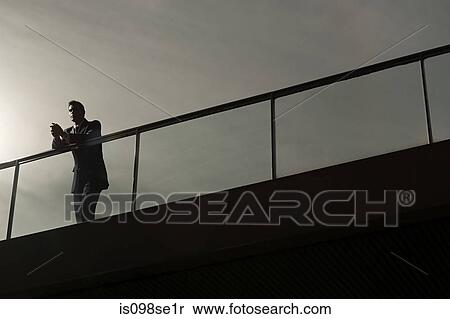 Silhouette of a businessman on a bridge View Large Photo Image Stock Photography - Silhouette of a businessman on a bridge. Fotosearch
