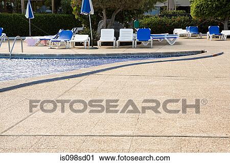 Sun loungers beside a swimming pool View Large Photo Image Stock Image - Sun loungers beside a swimming pool. Fotosearch