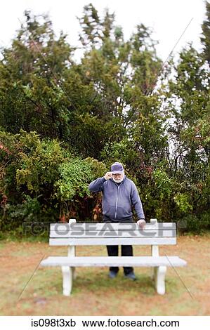 Man leaning on a bench View Large Photo Image Stock Image - Man leaning on a bench. Fotosearch