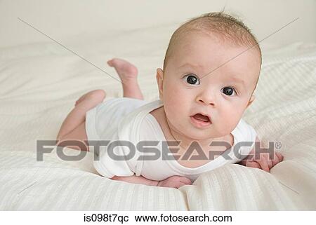 Baby lying on bed View Large Photo Image Stock Image - Baby lying on bed. Fotosearch