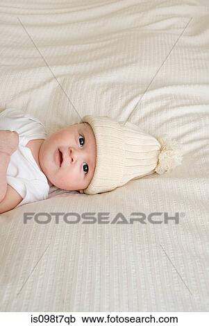 Stock Image - Baby wearing a bobble hat. Fotosearch