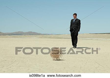 Businessman in desert with tumbleweed View Large Photo Image Stock Image - Businessman in desert with tumbleweed. Fotosearch