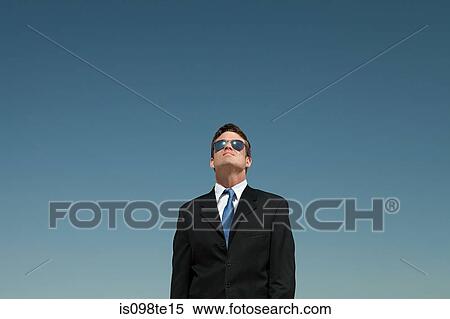 Businessman wearing sunglasses and looking up View Large Photo Image Stock Photography - Businessman wearing sunglasses and looking up. Fotosearch