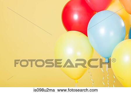 Colourful party balloons against yellow background View Large Photo Image Stock Image - Colourful party balloons against yellow background. Fotosearch
