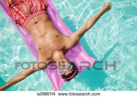 Man on inflatable mattress in pool View Large Photo Image Picture - Man on inflatable mattress in pool. Fotosearch