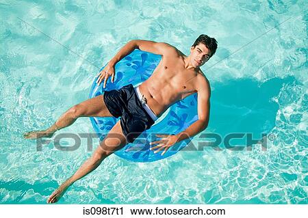 Man on inflatable ring in pool View Large Photo Image Stock Image - Man on inflatable ring in pool. Fotosearch