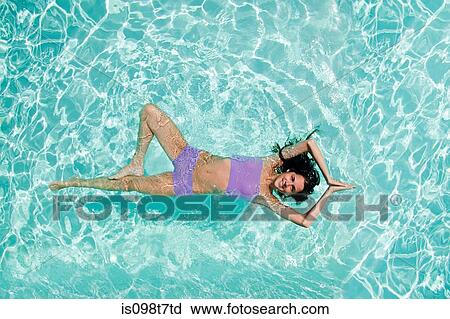 Stock Image - Woman practicing yoga in swimming pool. Fotosearch