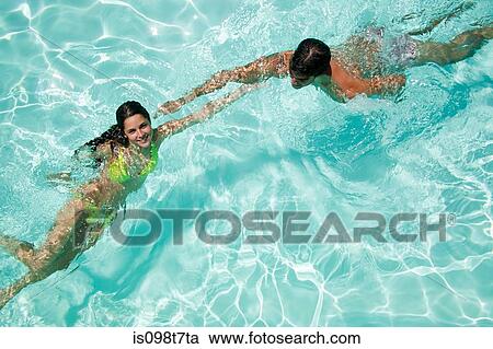 Stock Image - Young couple in swimming pool. Fotosearch