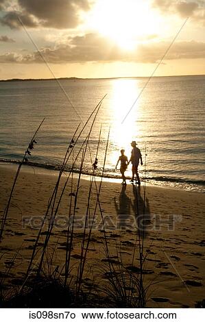 Couple on beach at sunset. View Large Photo Image Picture - Couple on beach at sunset.. Fotosearch