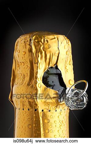 Stock Image - Close up of champagne bottle almost open. Fotosearch