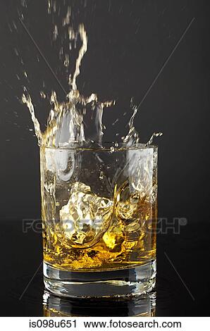 Ice cube splashing in tumbler of whiskey View Large Photo Image Stock Image - Ice cube splashing in tumbler of whiskey. Fotosearch