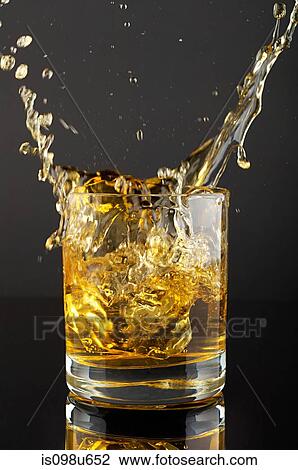 Ice cube splashing in tumbler of whiskey View Large Photo Image Stock Image - Ice cube splashing in tumbler of whiskey. Fotosearch