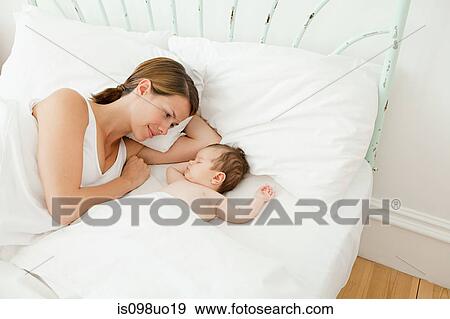 Mother watching baby girl sleep View Large Photo Image Stock Photo - Mother watching baby girl sleep. Fotosearch