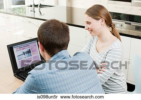 Young couple looking at travel insurance on laptop View Large Photo Image Stock Photography - Young couple looking at travel insurance on laptop. Fotosearch