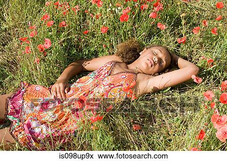 Young girl lying in poppy field View Large Photo Image Stock Photo - Young girl lying in poppy field. Fotosearch