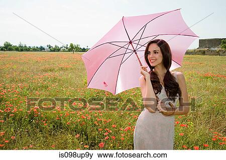 Young woman in poppy field with pink parasol View Large Photo Image Stock Photo - Young woman in poppy field with pink parasol. Fotosearch