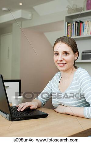 Young woman using laptop View Large Photo Image Picture - Young woman using laptop. Fotosearch