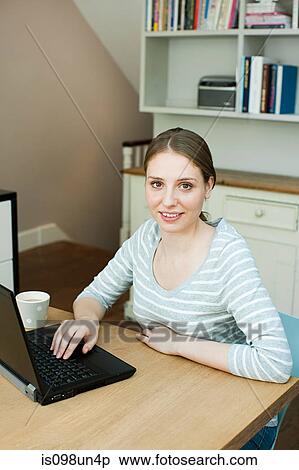 Young woman using laptop View Large Photo Image Stock Photography - Young woman using laptop. Fotosearch