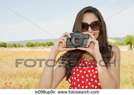 Young woman with camera in poppy field View Large Photo Image Stock Photo - Young woman with camera in poppy field. Fotosearch