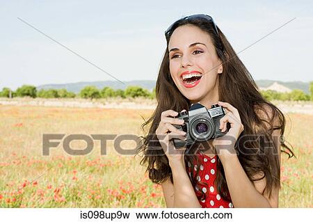 Young woman with camera in poppy field View Large Photo Image Stock Photo - Young woman with camera in poppy field. Fotosearch