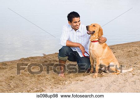 Man and golden retriever at the beach View Large Photo Image Stock Photo - Man and golden retriever at the beach. Fotosearch