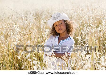 Stock Photograph - Girl wearing white cowboy hat in field. Fotosearch