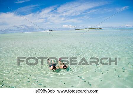 Stock Image - Mid adult couple snorkeling and looking at fish. Fotosearch