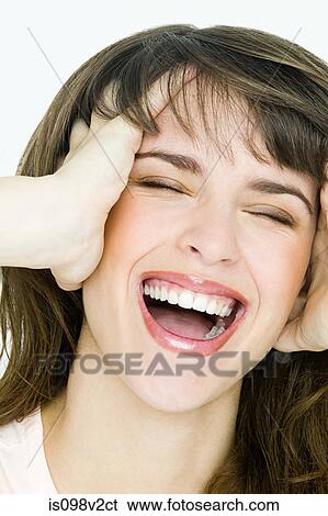 Stock Photograph - Portrait of young brunette woman with hands in hair. Fotosearch