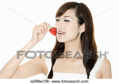 Stock Image - Woman eating strawberry. Fotosearch