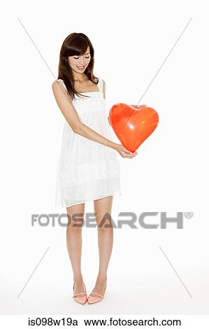 Woman holding red heart shaped balloon, studio shot View Large Photo Image Stock Image - Woman holding red heart shaped balloon, studio shot. Fotosearch