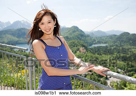 Woman standing by fence overlooking Allgaeu, Bavaria, Germany View Large Photo Image Stock Image - Woman standing by fence overlooking Allgaeu, Bavaria, Germany. Fotosearch