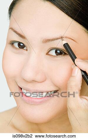 Young woman applying eyebrow pencil View Large Photo Image Stock Image - Young woman applying eyebrow pencil. Fotosearch