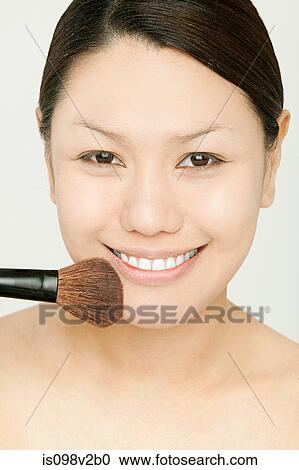 Young woman applying face powder View Large Photo Image Stock Image - Young woman applying face powder. Fotosearch