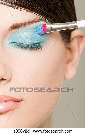Young woman applying turquoise eyeshadow View Large Photo Image Stock Image - Young woman applying turquoise eyeshadow. Fotosearch