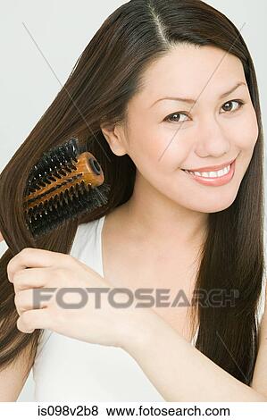 Stock Photo - Young woman brushing hair. Fotosearch