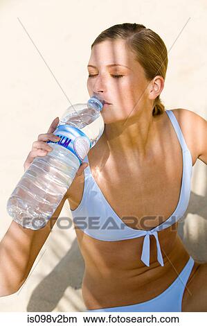 Picture - Young woman drinking mineral water. Fotosearch