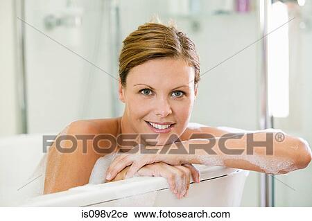 Stock Image - Young woman having a bath. Fotosearch