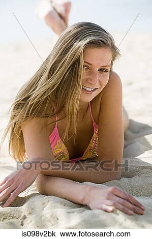 Young woman lying on sand on vacation View Large Photo Image Stock Image - Young woman lying on sand on vacation. Fotosearch