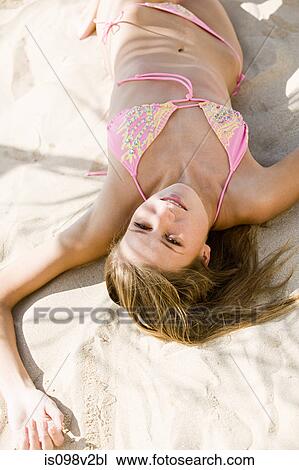 Young woman lying on sand on vacation View Large Photo Image Stock Image - Young woman lying on sand on vacation. Fotosearch