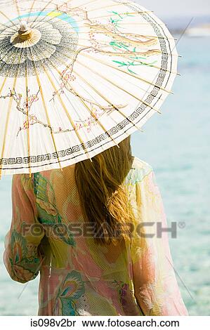 Stock Photography - Young woman on vacation with parasol. Fotosearch