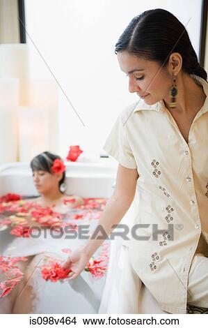 Young woman relaxing in aromatherapy bath with petals View Large Photo Image Picture - Young woman relaxing in aromatherapy bath with petals. Fotosearch