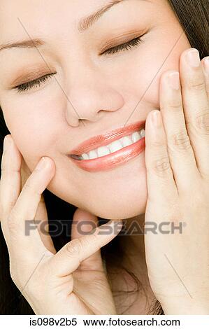 Stock Photography - Young woman touching face. Fotosearch