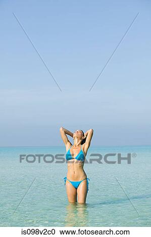 Stock Image - Young woman wearing bikini in sea. Fotosearch