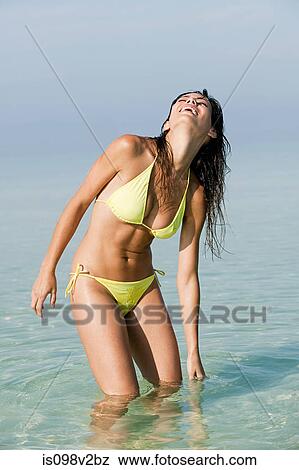 Stock Photo - Young woman wearing bikini in sea. Fotosearch