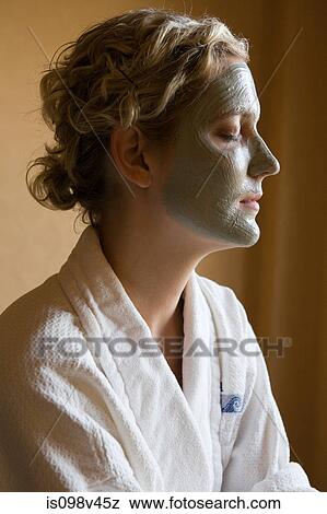 Stock Photo - Young woman with mud mask on face. Fotosearch