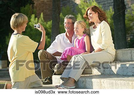 Boy taking photograph of family View Large Photo Image Stock Photo - Boy taking photograph of family. Fotosearch