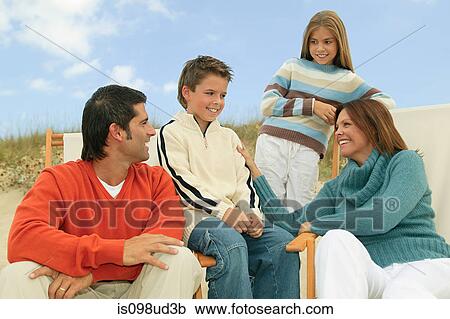 Stock Image - Family in deck chairs at the beach. Fotosearch