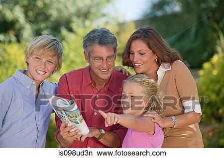 Family looking at guidebook and pointing View Large Photo Image Picture - Family looking at guidebook and pointing. Fotosearch