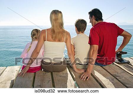 Family sitting on jetty together View Large Photo Image Stock Image - Family sitting on jetty together. Fotosearch
