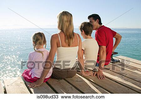 Family sitting on jetty together View Large Photo Image Stock Image - Family sitting on jetty together. Fotosearch